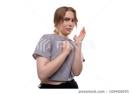 A teenage girl with brown hair looks at the camera in surprise 109488045