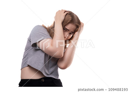Portrait of a timid teenage girl with blond hair in a gray T-shirt on a white background Portrait of a timid teenage girl with blond hair in a gray T-shirt on a white background 109488193