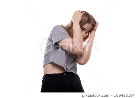 Fearful teenage girl with blond hair in a T-shirt on a white background Fearful teenage girl with blond hair in a T-shirt on a white background 109488194