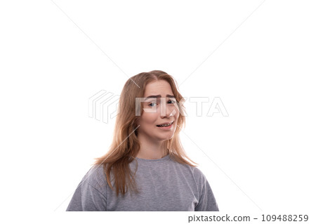 Smiling teenage girl with blond hair in a T-shirt on a white background 109488259