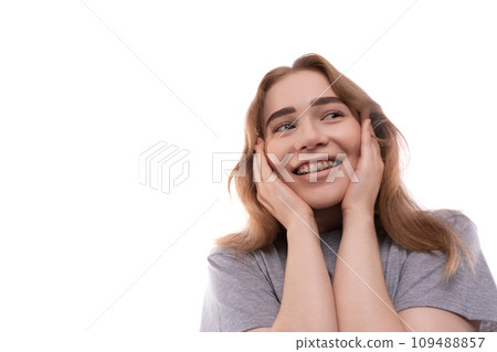Kind modest bright blond teenager girl with braces in a gray T-shirt 109488857