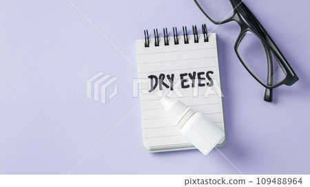 Dry eyes concept with eye drops with eyeglasses on pastel violet background, top view, copy space 109488964