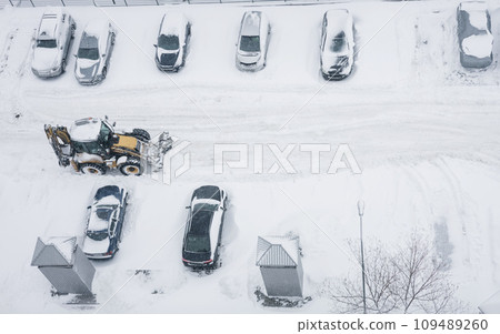 Tractor cleaning city street, removing snow and ice Tractor cleaning city street, removing snow and ice 109489260