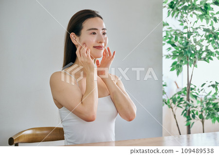 30多歲的女人透過按摩臉部來護理皮膚 30多歲的女人透過按摩臉部來護理皮膚 109489538