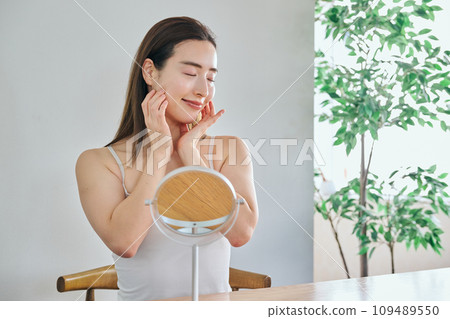 30多歲的女人透過按摩臉部來護理皮膚 109489550