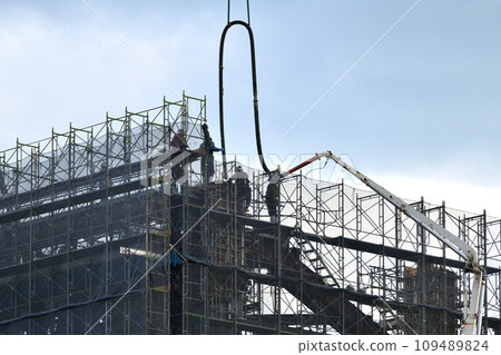Construction site Concrete pouring work Hanging hoses with a crane for high-altitude work 109489824