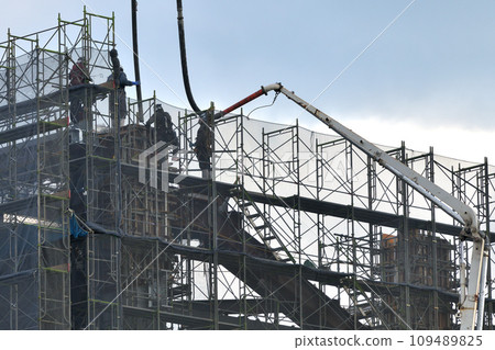 Construction site Concrete pouring work Hanging hoses with a crane for high-altitude work Construction site Concrete pouring work Hanging hoses with a crane for high-altitude work 109489825
