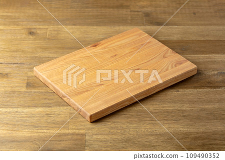 Cutting board on a wooden table. 109490352