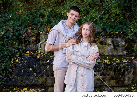 Warm Embrace of Teen Love in the Autumn Park. Capturing Teen Moments: Love Blossoms in Autumn's Embrace. Teenagers in Love: Embracing the Autumn Vibe 109490456