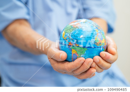 Bangkok, Thailand, January 1, 2023 Asian senior elderly old lady woman patient holding globe in hand on bed in nursing hospital Bangkok, Thailand, January 1, 2023 Asian senior elderly old lady woman patient holding globe in hand on bed in nursing hospital 109490485