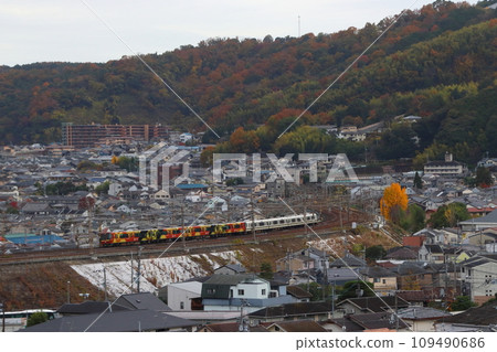 Tokaido Main Line 223 series (Kyoto QR train in the forest) seen from the hill of Yamashina Canal in autumn Tokaido Main Line 223 series (Kyoto QR train in the forest) seen from the hill of Yamashina Canal in autumn 109490686