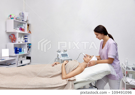 cosmetologist doing anti aging procedure in beauty salon cosmetologist doing anti aging procedure in beauty salon 109491096