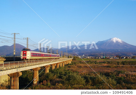 381系特急八雲號是一輛標準、寬敞、深色的列車，行駛在日野川的鐵路長橋上，與白雪皚皚的富士山相映成趣。 109491406