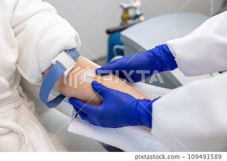 Woman receiving intravenous vitamin therapy in wellness center or beauty salon sitting in armchair. 109491589
