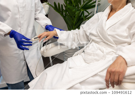 Nurse checking oxygen level to female patient in beauty salon before cosmetology procedures. 109491612