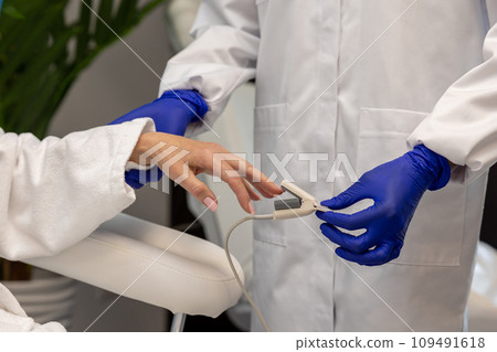Unknown nurse checking oxygen level through oximeter to female patient. 109491618