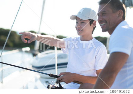 Teen and his dad on a yacht with a fishing rod Teen and his dad on a yacht with a fishing rod 109491632