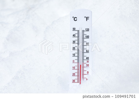 Outdoor thermometer in snow shows low winter temperature 109491701