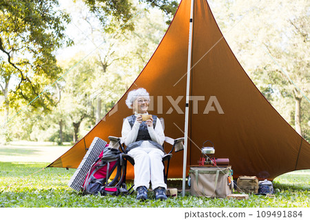 A woman in her 60s enjoying camping A woman in her 60s enjoying camping 109491884