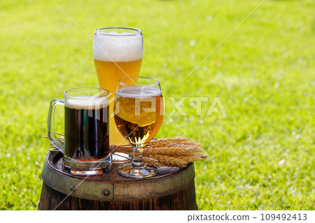 Variety of beer glasses on rustic wooden barrel 109492413