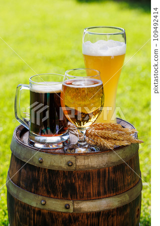 Variety of beer glasses on rustic wooden barrel 109492414