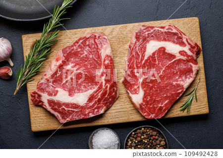 Raw ribeye steaks with savory spices Raw ribeye steaks with savory spices 109492428