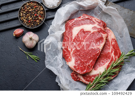 Raw ribeye steaks with savory spices 109492429