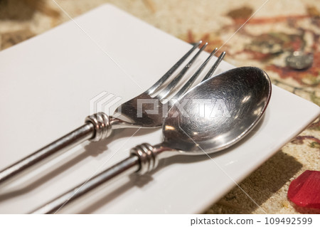 Spoon and Fork on napkin, ready to use. On the table, in restaurant 109492599