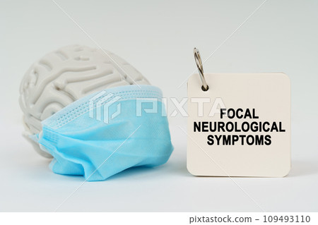 On a white surface there is a brain with a blue mask and a notepad with the inscription - focal neurological symptoms 109493110