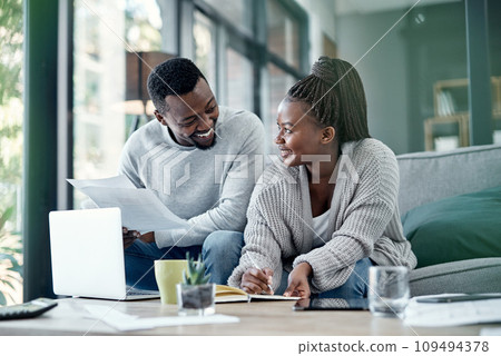 Couple planning finance investments, insurance and banking bills papers together at home. Happy husband and young wife smiling over their financial budget report information and household money plan 109494378