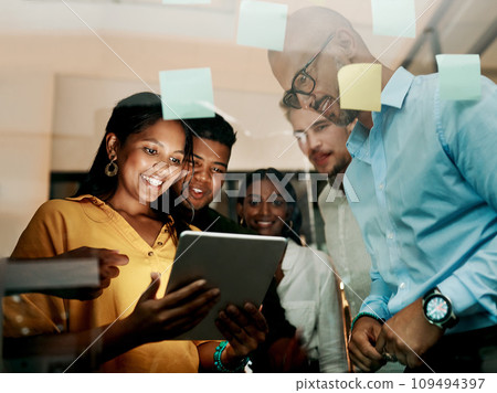 Group of creative, excited and smiling design team, working, researching and browsing on tablet for innovation ideas in modern office. Office workers planning a group work project after hours. Group of creative, excited and smiling design team, working, researching and browsing on tablet for innovation ideas in modern office. Office workers planning a group work project after hours. 109494397