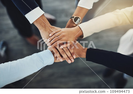 Hands stacked or piled to show team unity, strength or motivation among business men, women or colleagues from above. Closeup of huddled, motivated group of businesspeople in support and trust circle Hands stacked or piled to show team unity, strength or motivation among business men, women or colleagues from above. Closeup of huddled, motivated group of businesspeople in support and trust circle 109494473