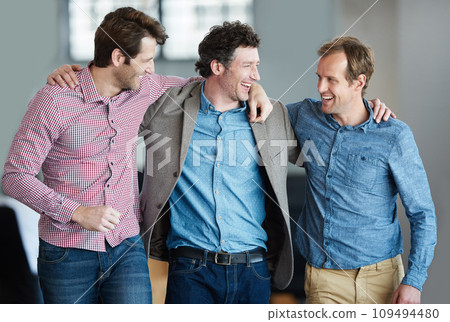 Teamwork, friendship and support with colleagues standing together in a huddle laughing and feeling happy in a creative office. Business men embracing each other sharing trust, joy and unity 109494480