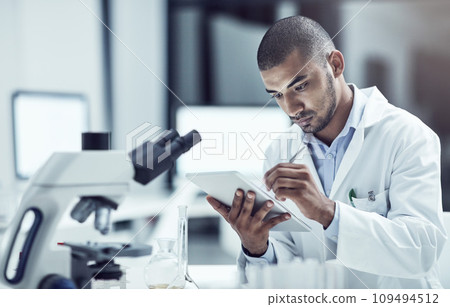 Laboratory scientist or science professional with tablet writing or recording medical research innovation in healthcare centre. Serious biologist searching for pandemic virus vaccine cure on lab tech 109494512