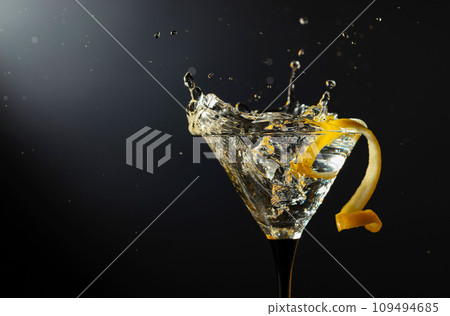 Glass of classic dry martini cocktail with green olives on a black background. 109494685