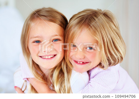 Portrait, sisters and hug indoors with love for relax wellness, happiness and sibling support in home. Children, girls and smile face for fun morning in embrace, family and bonding for care in house 109494706