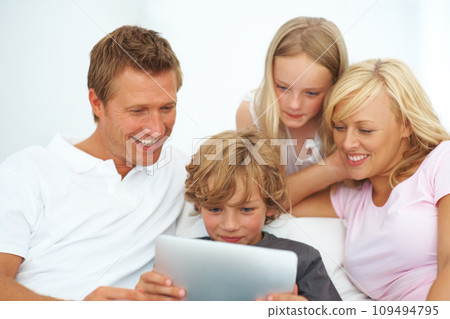 Mother, father and kids smile with tablet for elearning, video games or reading ebook story on app at family home. Mom, dad and children watching cartoon, streaming digital multimedia or subscription Mother, father and kids smile with tablet for elearning, video games or reading ebook story on app at family home. Mom, dad and children watching cartoon, streaming digital multimedia or subscription 109494795