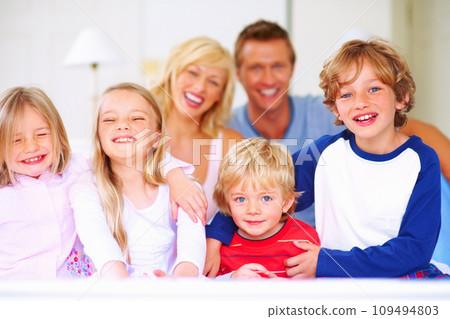 Smile, portrait and parents with children on bed for bonding, relaxing and spending time together. Happy, love and young mother and father resting with kids from Australia in bedroom at family home. 109494803