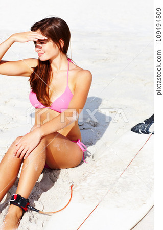 Beach, view and a woman surfer in a bikini on the sand for sports, fitness or vacation during summer. Travel, relax and a happy young person on the coast with a surfboard by the ocean or sea 109494809
