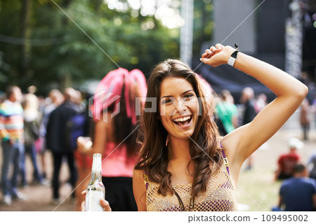 Music, festival and portrait of woman at a concert, stage and celebration with alcohol, bottle or beer at event. Happy, girl and dancing at party with audience, crowd and excited fan at techno rave Music, festival and portrait of woman at a concert, stage and celebration with alcohol, bottle or beer at event. Happy, girl and dancing at party with audience, crowd and excited fan at techno rave 109495002