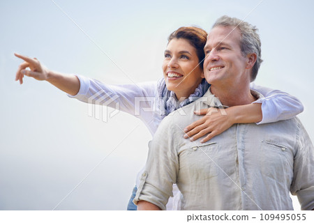Happy couple, pointing and travel together with love, happiness and cruise adventure in summer. Retirement, vacation and mature man and woman hug and sightseeing on holiday with sky mockup space 109495055