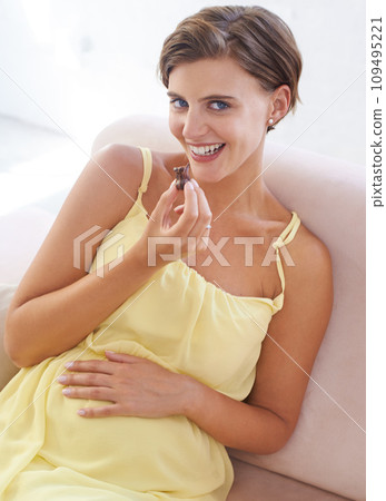 Pregnant woman, eating chocolate and happy in home, alone and enjoying delicious pregnancy craving. Good mood, comfort food and candy dessert for maternity, snack and sweet tooth satisfaction Pregnant woman, eating chocolate and happy in home, alone and enjoying delicious pregnancy craving. Good mood, comfort food and candy dessert for maternity, snack and sweet tooth satisfaction 109495221