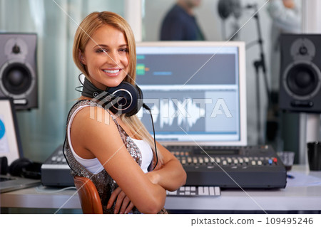 Portrait, smile and a woman music engineer in studio for recording sound or audio as a producer. Computer, software and art with a happy young DJ arms crossed at her desk for professional production Portrait, smile and a woman music engineer in studio for recording sound or audio as a producer. Computer, software and art with a happy young DJ arms crossed at her desk for professional production 109495246
