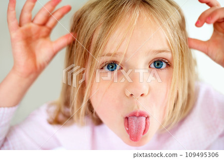 Silly, tongue out and portrait of child in home with funny, comic and humor facial expression. Childhood, crazy and closeup of young girl with hand gesture for goofy face, playful joke and emoji Silly, tongue out and portrait of child in home with funny, comic and humor facial expression. Childhood, crazy and closeup of young girl with hand gesture for goofy face, playful joke and emoji 109495306