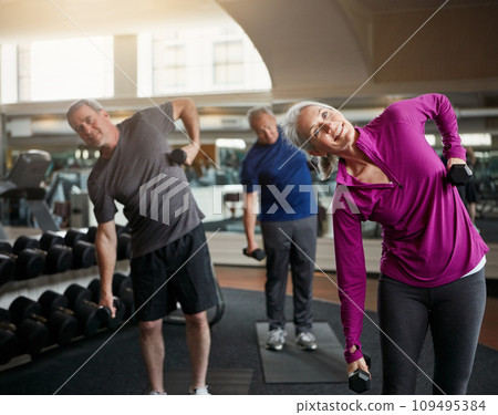 Senior fitness club, stretching and people with dumbbells at gym for training, wellness or exercise. Class, workout and elderly men with personal trainer for weightlifting, support or bodybuilding 109495384
