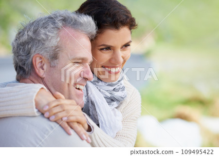 Couple, face and laughing in nature with hug for romance, love and relationship outdoor with date. Mature, man and woman or embrace with happy, marriage and trust for bonding, honeymoon and support 109495422