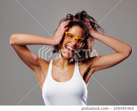 Portrait, smile and crazy with a messy hair woman in studio on a gray background for silly expression. Fashion, glasses and a happy young person feeling goofy with energy, freedom or excitement Portrait, smile and crazy with a messy hair woman in studio on a gray background for silly expression. Fashion, glasses and a happy young person feeling goofy with energy, freedom or excitement 109495468