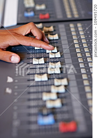 Hand, mixing and sound board in recording studio with dj, technology and media on desk. Music, deck and person editing with equipment for audio, production and moving switch on console for radio song Hand, mixing and sound board in recording studio with dj, technology and media on desk. Music, deck and person editing with equipment for audio, production and moving switch on console for radio song 109495720