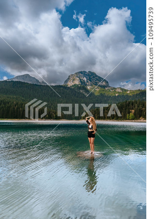 Woman Traveler Standing in Mountain Black Lake Woman Traveler Standing in Mountain Black Lake 109495739