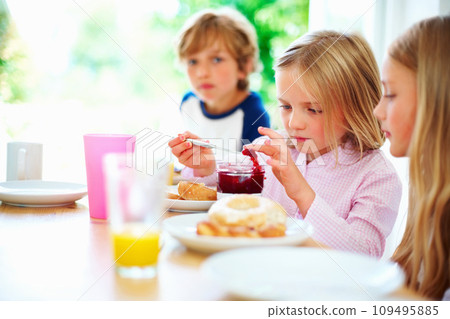 Family, morning and breakfast jam, children and meal for nutrition, orange juice and bagel. Brother, sisters and enjoying food together for hunger, health and energy for home weekend activities 109495885